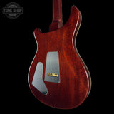 Back view of a wooden electric guitar with a visible brand logo in the corner.