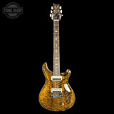 Electric guitar with a wavy wood finish on a black background, featuring the Tone Shop logo.