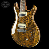 Electric guitar with a wavy wood finish on a black background, featuring 'Tone Shop' branding.