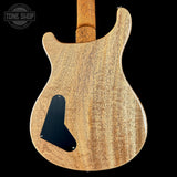 Back view of a wooden electric guitar with 'Tone Shop' logo.