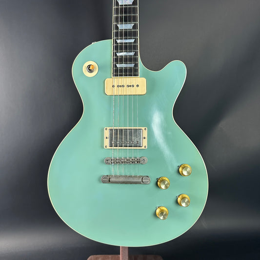 Light blue electric guitar with gold hardware on a dark background