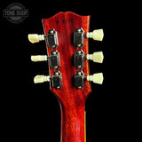 Close-up of a red guitar headstock with tuning pegs on a black background, featuring 'Tone Shop' branding.