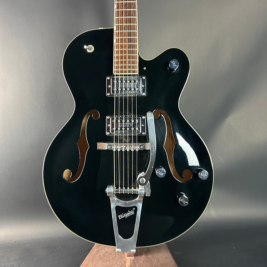 Black electric guitar on a gray background