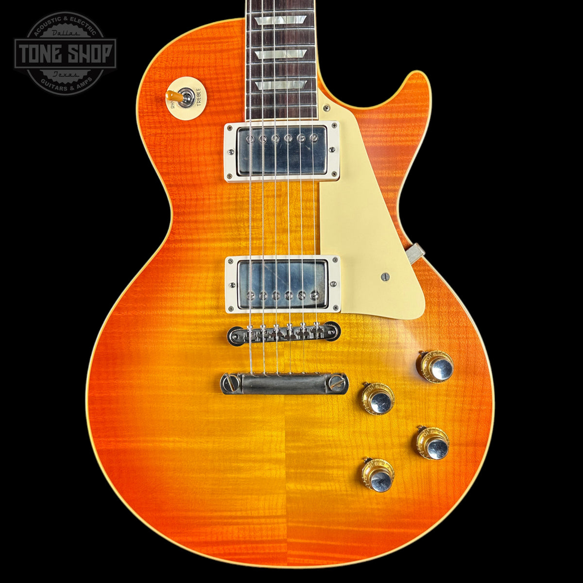 Orange electric guitar with a black background