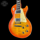 Orange electric guitar with a black background, featuring the Tone Shop logo.