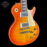 Orange electric guitar with a black background, featuring the 'Tone Shop' logo.