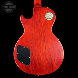 Back view of a red electric guitar with a visible brand logo on a black background