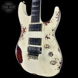 Distressed electric guitar with visible wear and tear on a black background, featuring the 'Tone Shop' logo.