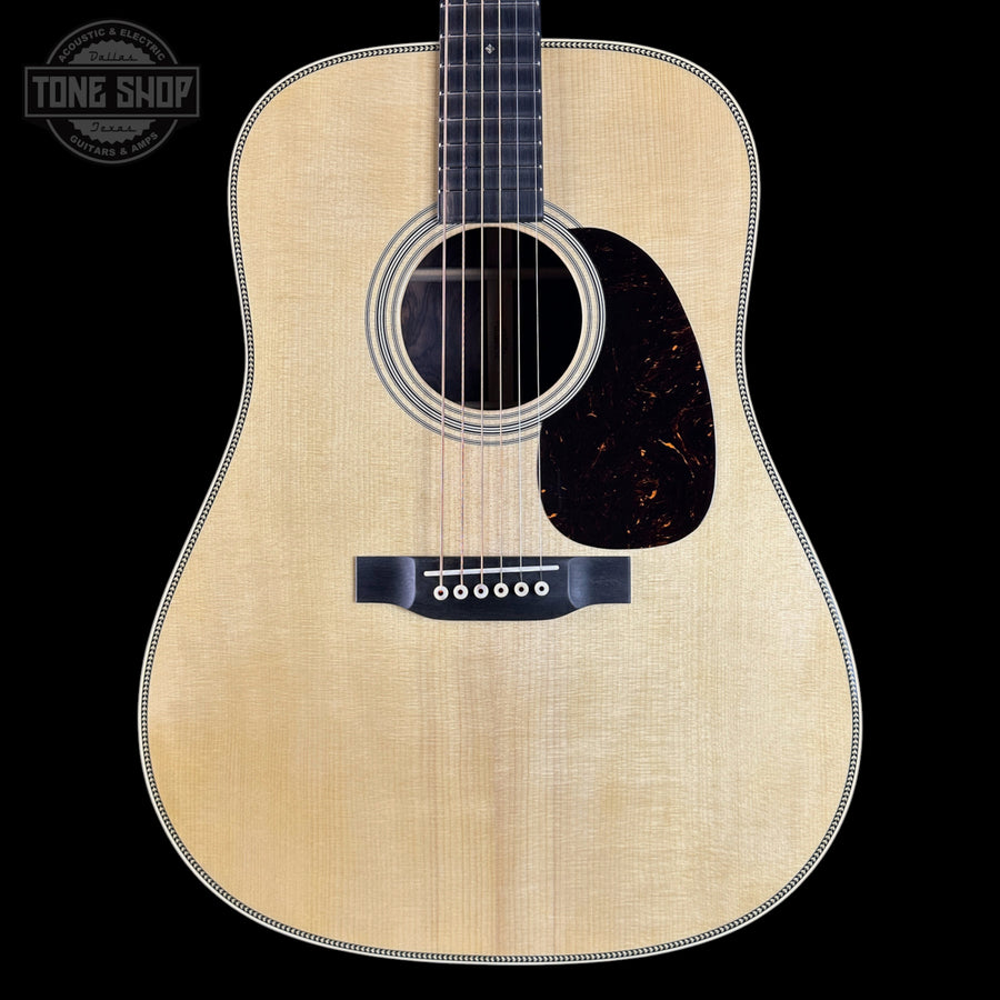 Acoustic guitar with a visible brand logo on a black background
