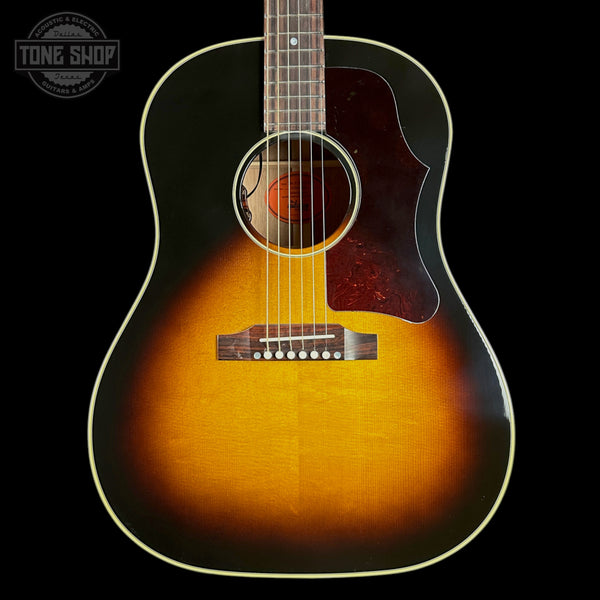 Acoustic guitar with a sunburst finish on a black background, featuring the Tone Shop logo.