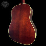 Back view of a wooden acoustic guitar with a dark brown finish on a black background, featuring the Tone Shop logo.