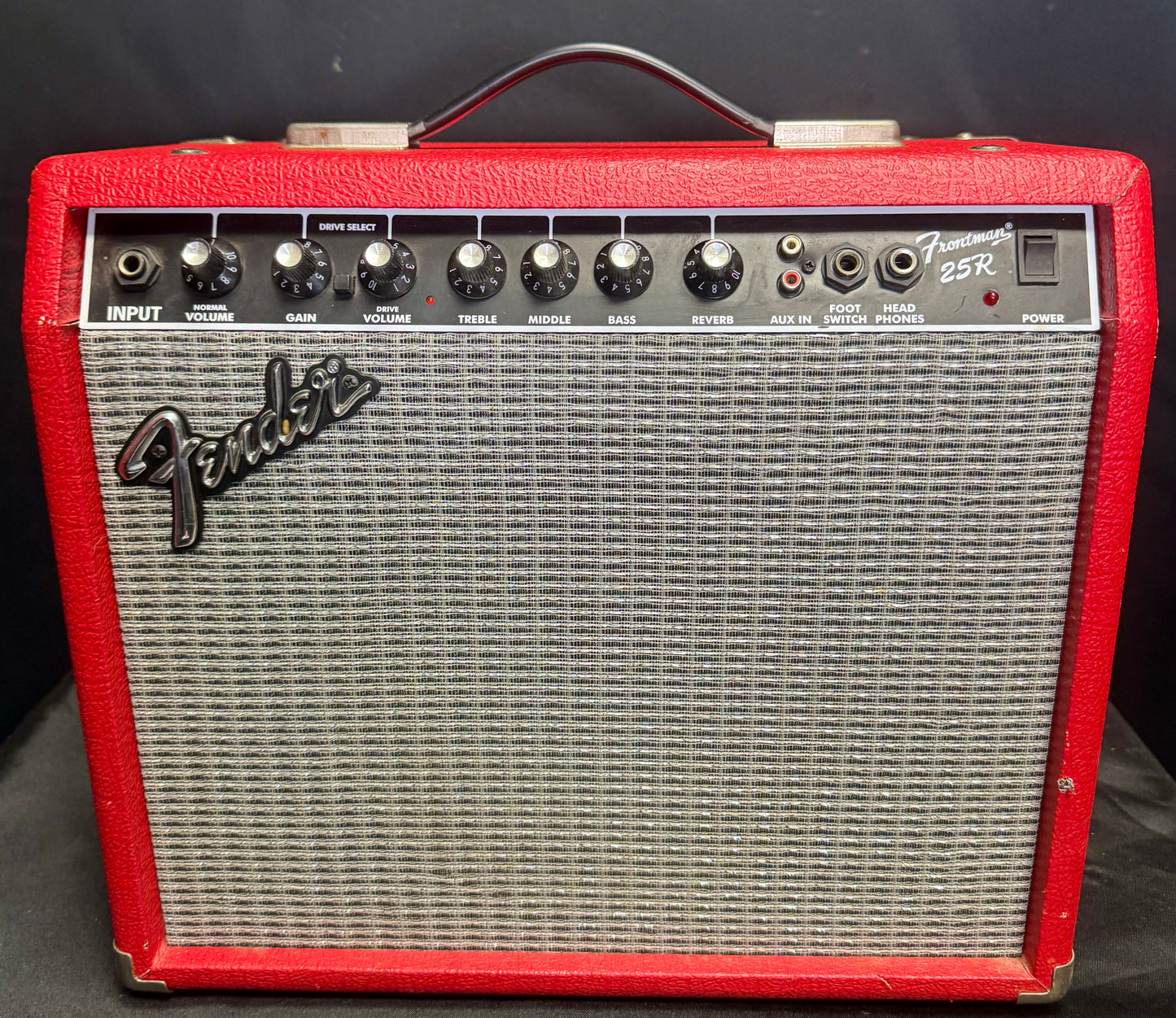 Fender guitar amplifier with red casing on a black background
