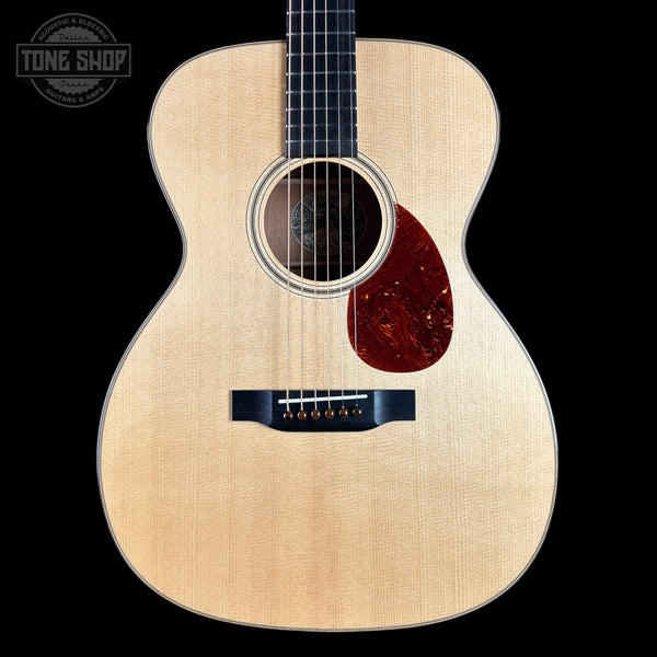 Acoustic guitar with a visible brand logo on a black background