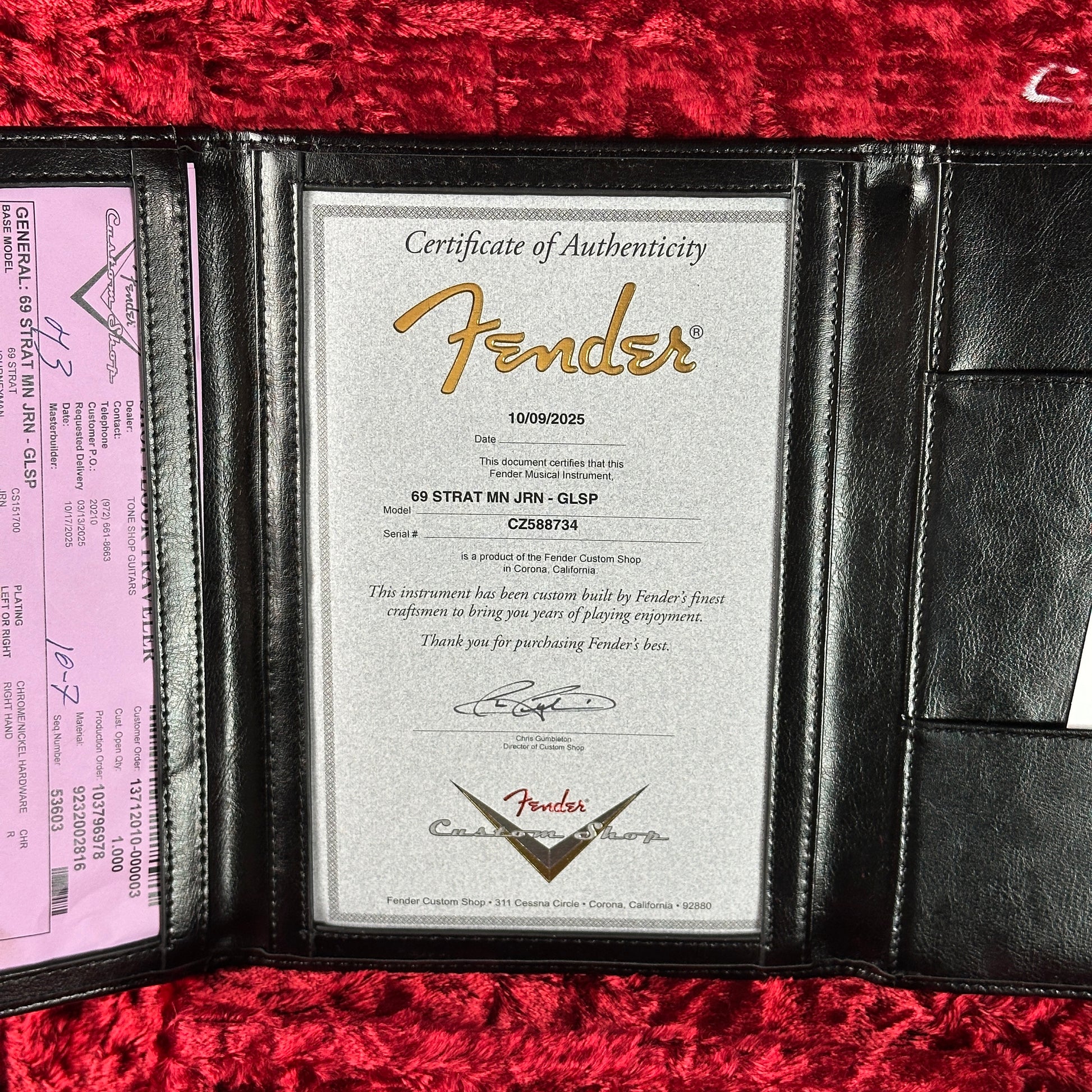 Fender certificate of authenticity in a black holder on a red textured surface