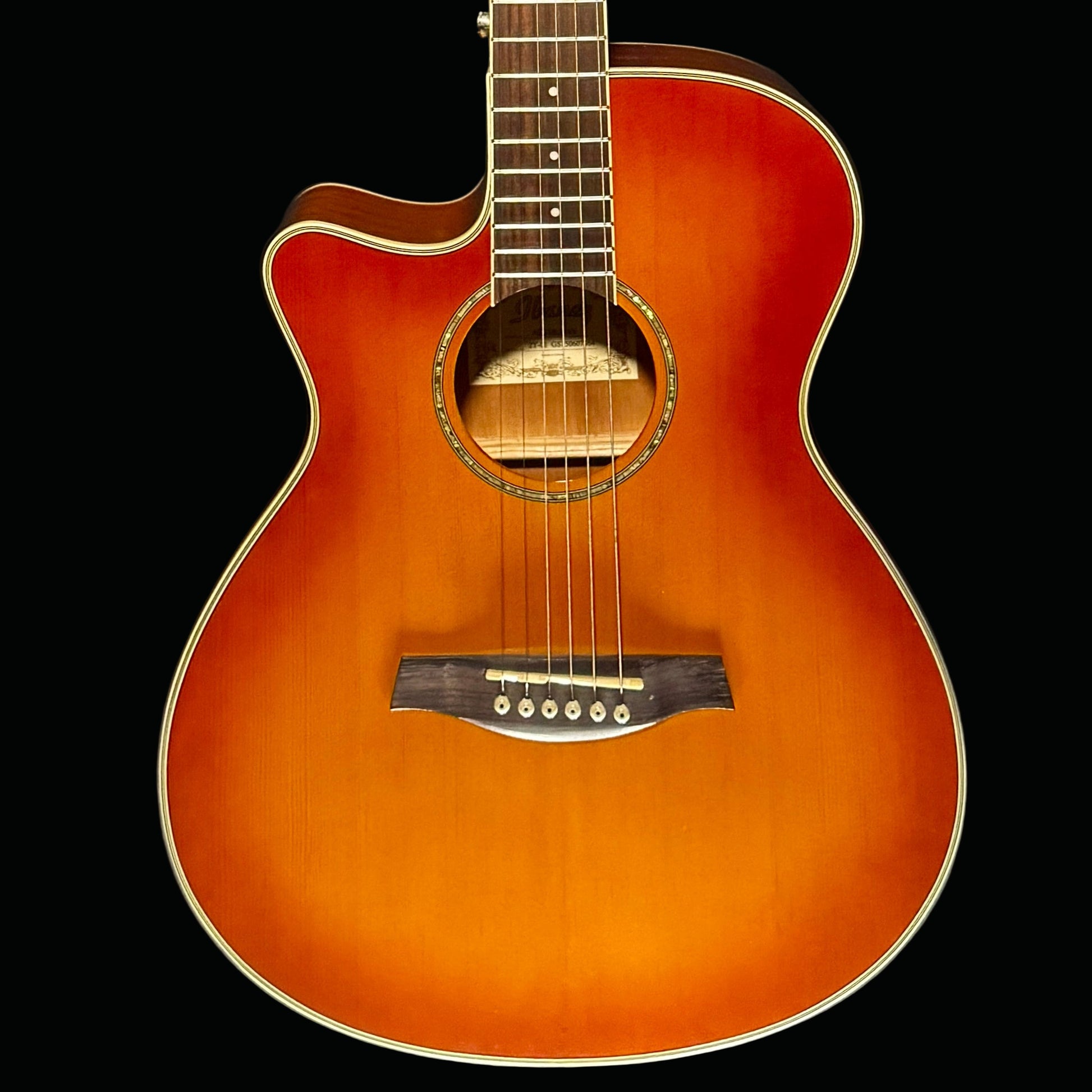 Acoustic guitar with a sunburst finish on a dark background