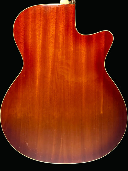 Back view of a wooden acoustic guitar on a dark background