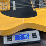 Yellow electric guitar on a digital scale displaying weight