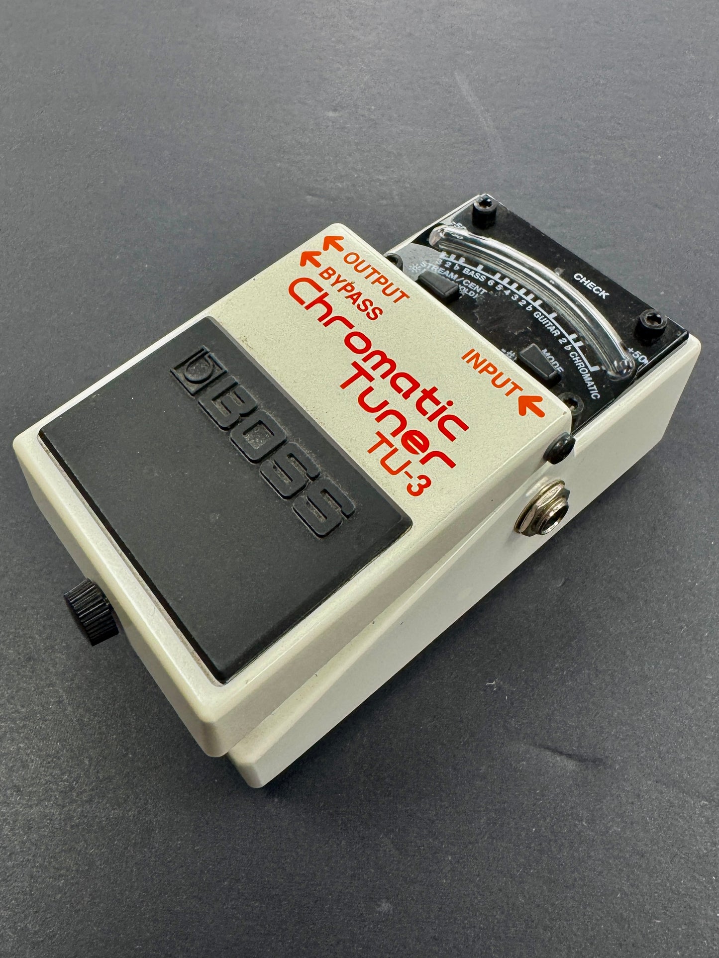 Chromatic tuner pedal on a dark background