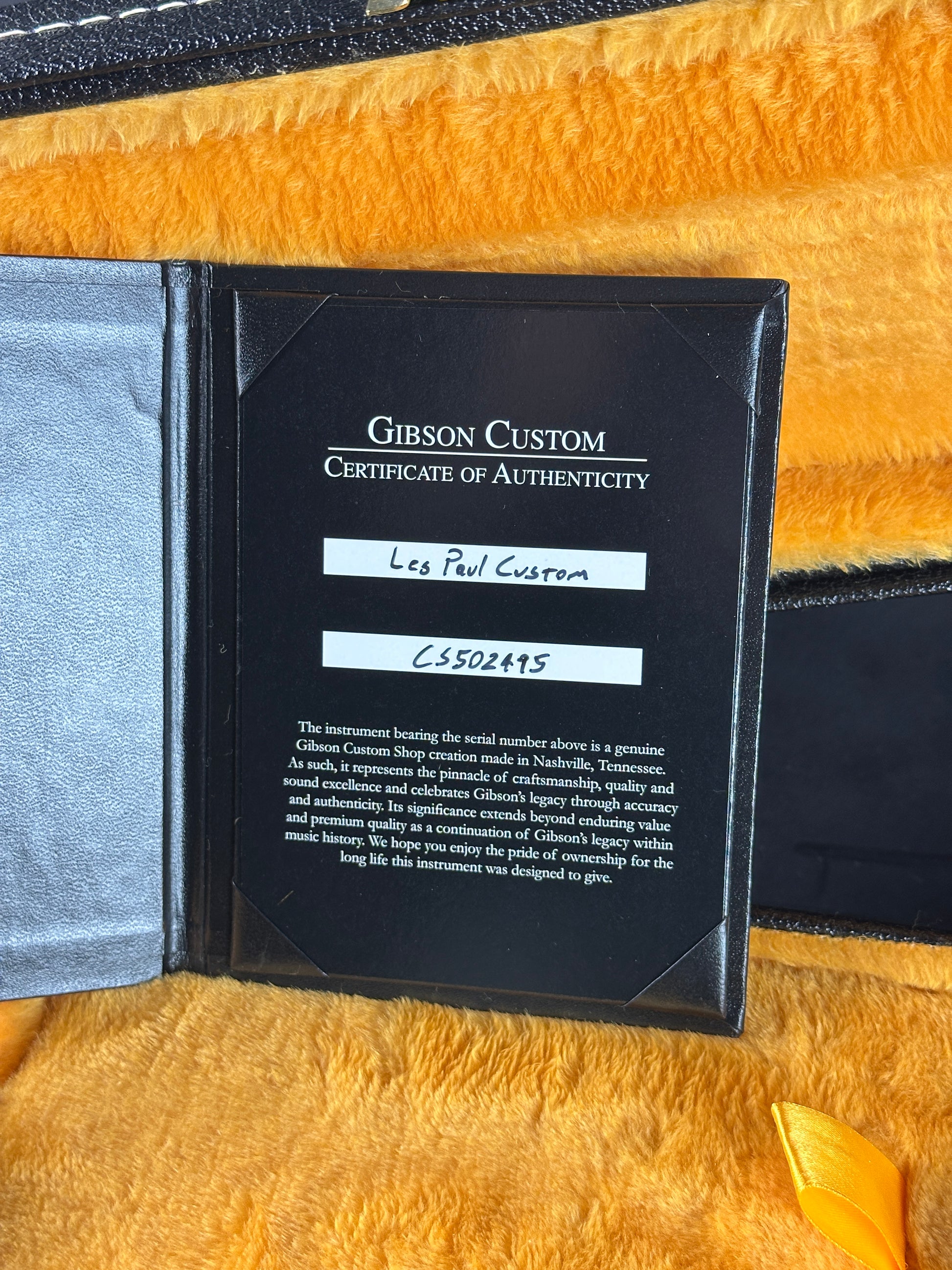 Gibson Custom Certificate of Authenticity on a textured yellow surface