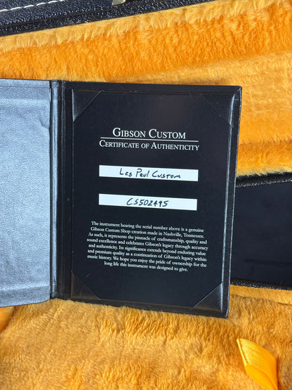 Gibson Custom Certificate of Authenticity on a textured yellow surface