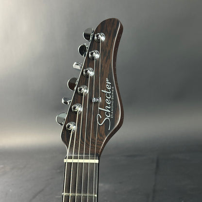 Guitar headstock with 'Schecter' branding on a gray background