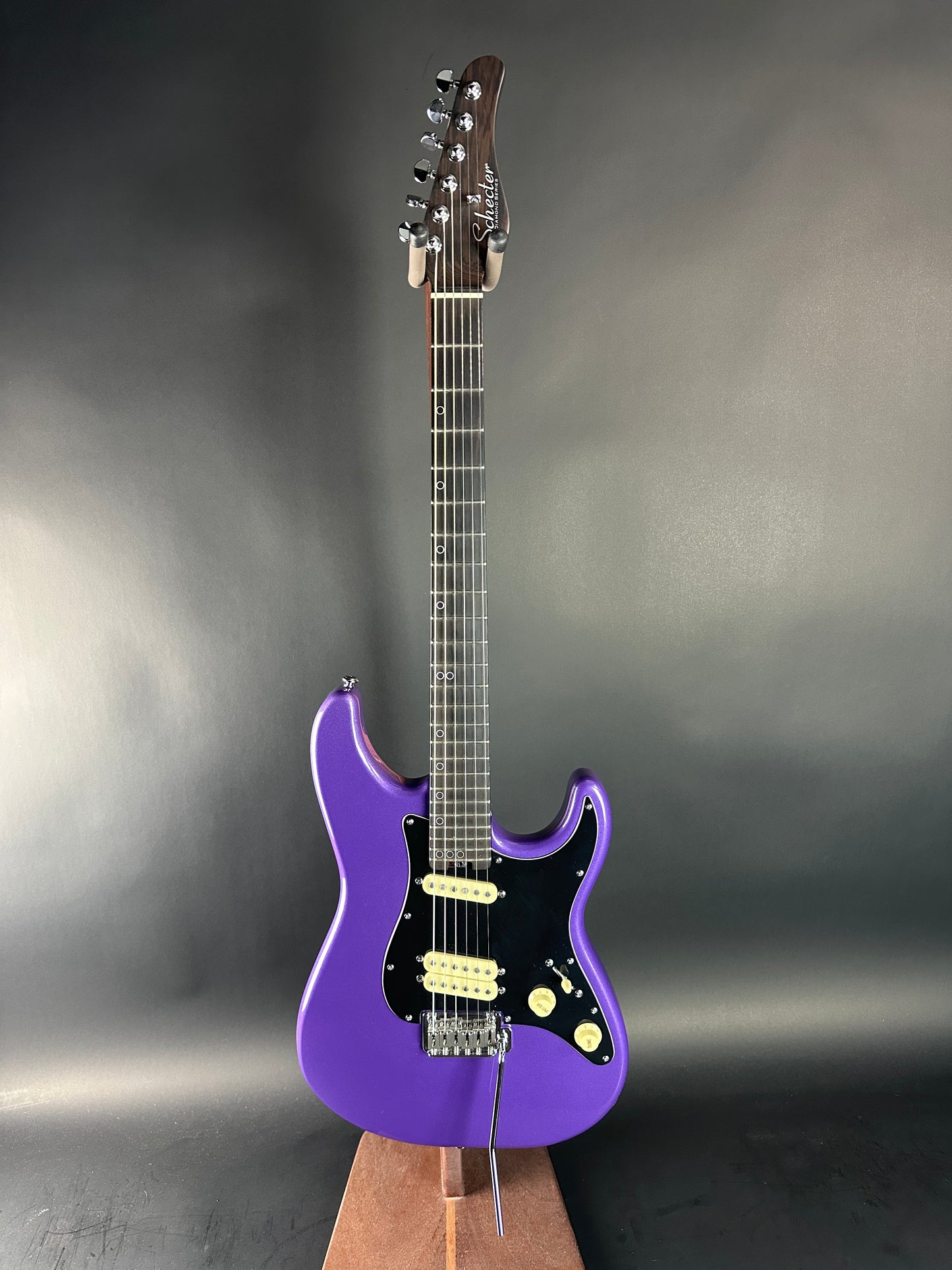 Purple electric guitar on a gray background