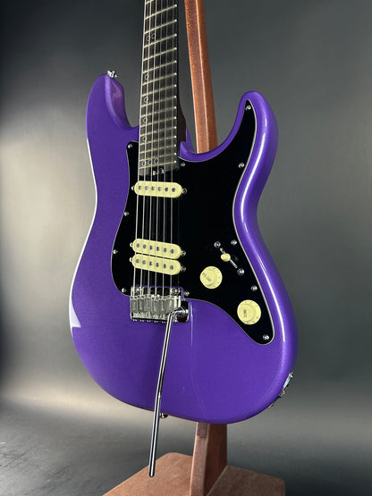 Purple electric guitar on a gray background