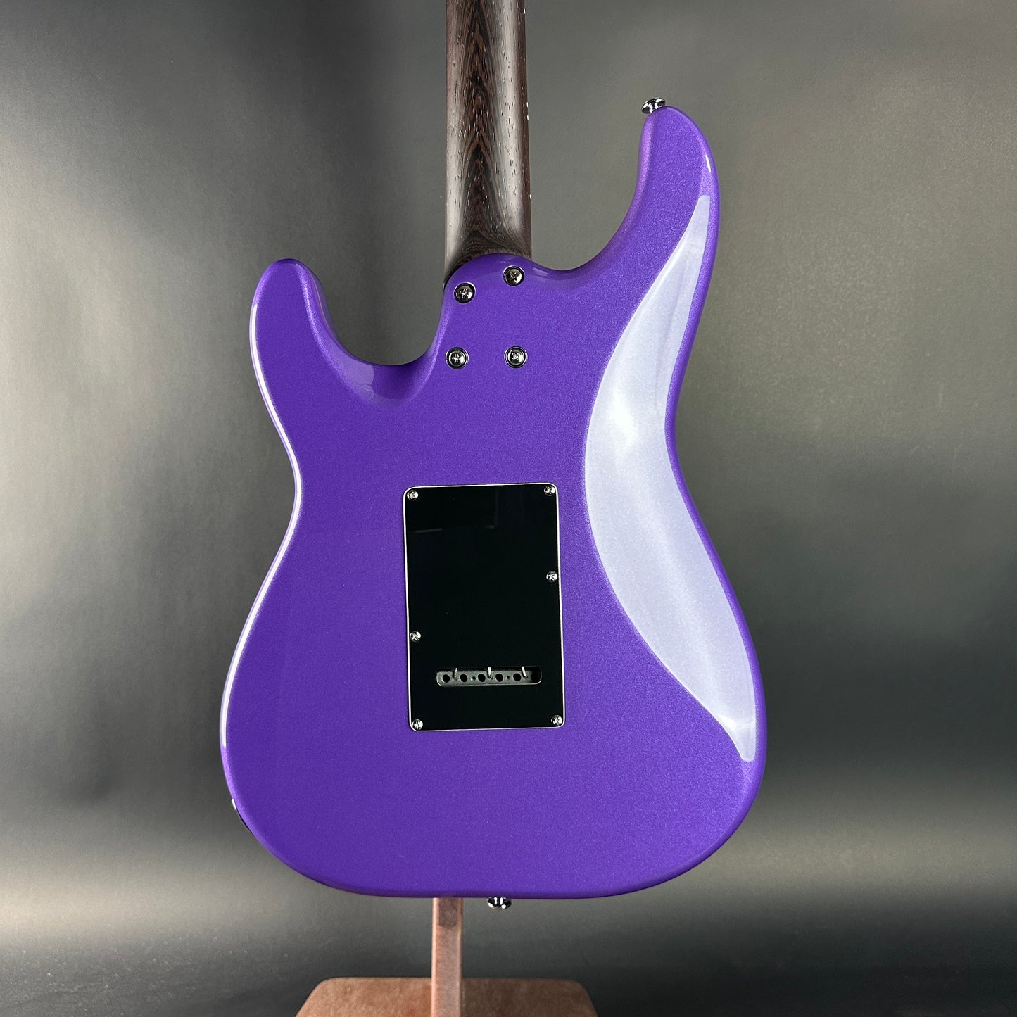 Purple electric guitar on a gray background