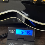 Used Gibson Les Paul Custom Ebony on scale displaying weight.
