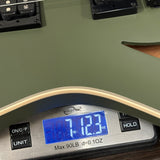 Digital scale displaying weight on a green surface