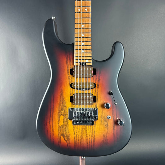 Electric guitar with sunburst finish on a gray background