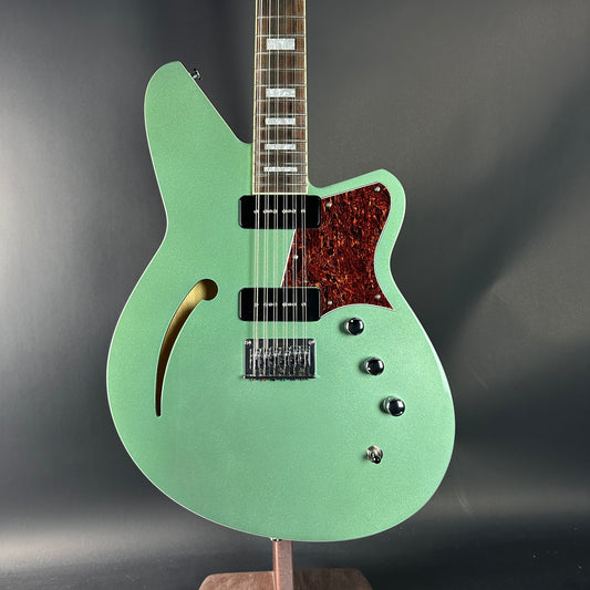 Green electric guitar on a dark gray background