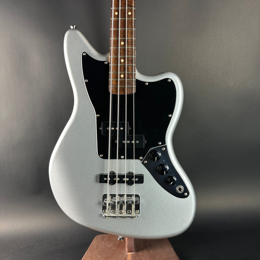 Silver electric bass guitar on a gray background