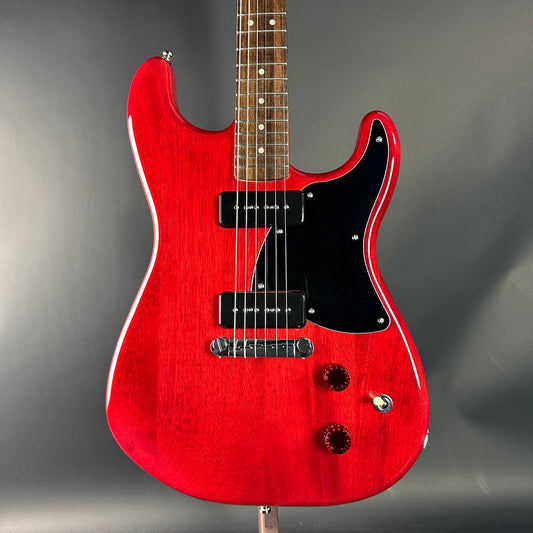 Red electric guitar on a gray background
