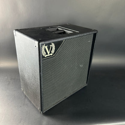 Black speaker cabinet with a logo on a gray background