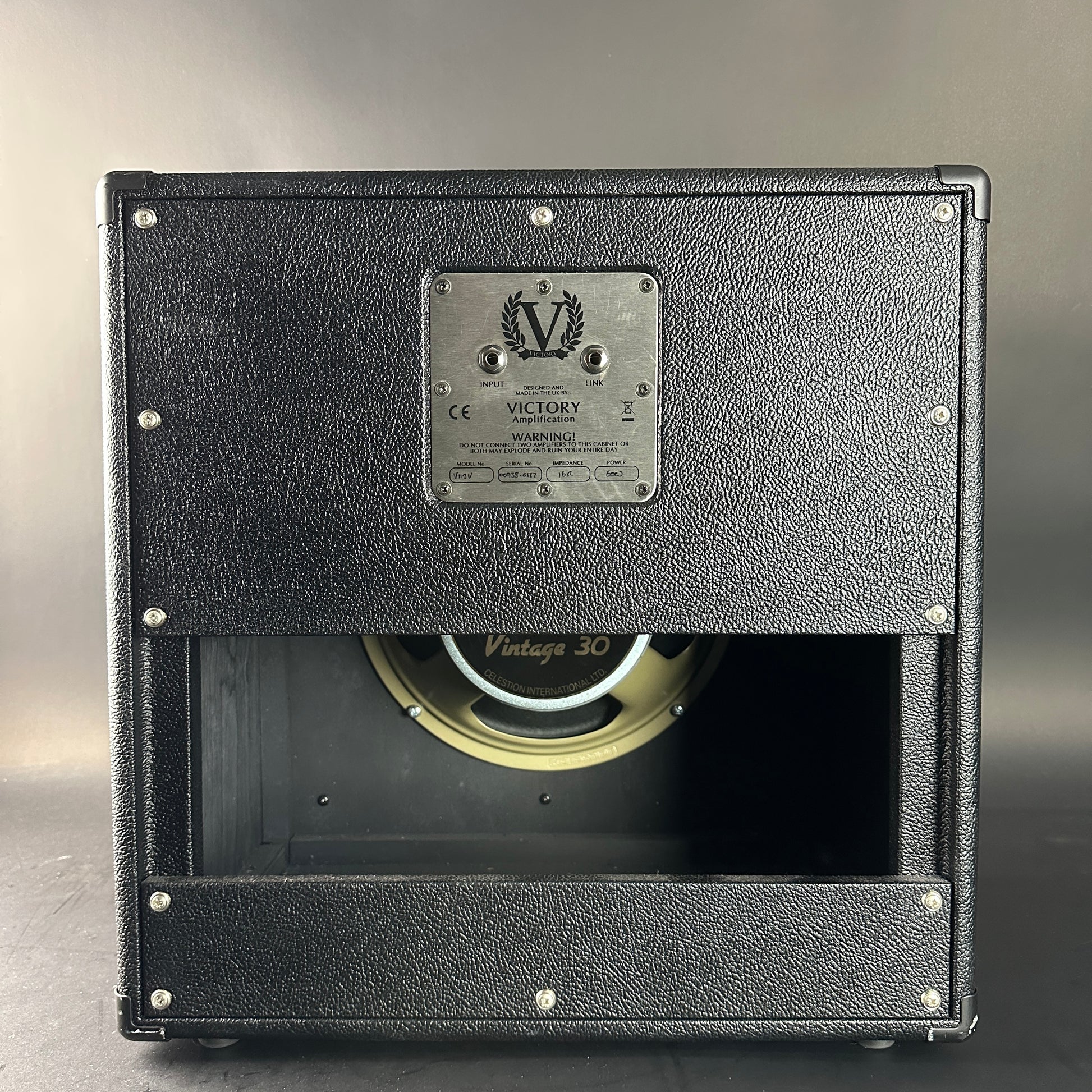 Black speaker cabinet with visible brand logo on a gray background