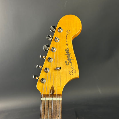 Guitar headstock with 'Squier' branding on a dark gray background