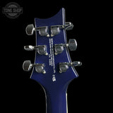 Close-up of a blue electric guitar's headstock with tuning pegs on a black background.