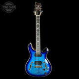 Blue electric guitar on a black background with 'Tone Shop' logo.