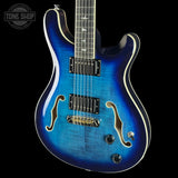 Blue electric guitar with a black pickguard on a white background