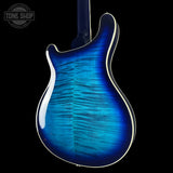 Blue electric guitar body with a black background