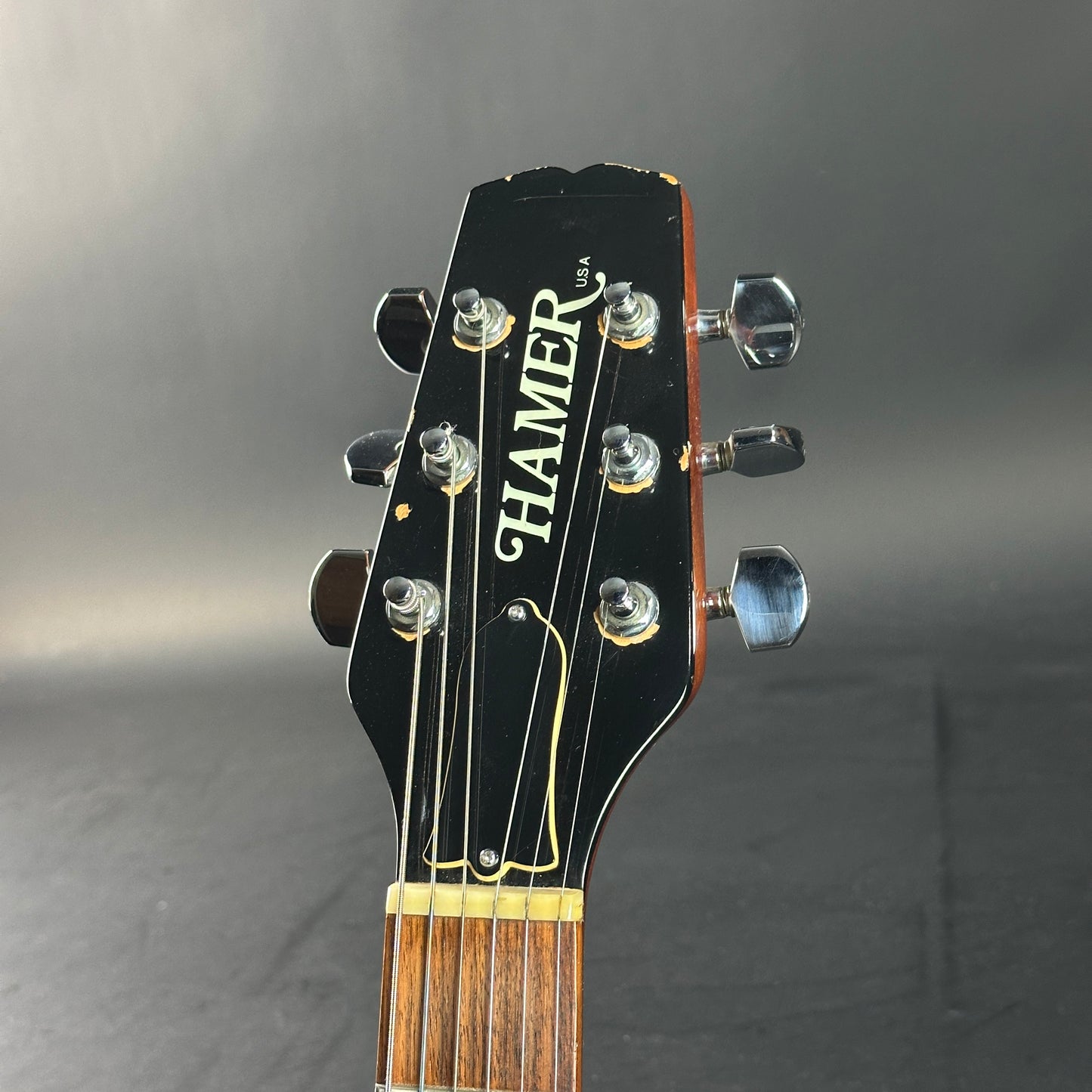 Guitar headstock with 'Hamer' branding on a gray background