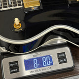 Used Gibson Dealer Select Les Paul Custom Chambered Ebony Murphy Ultra Light Aged on scale displaying weight.