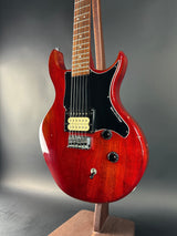 Red electric guitar on a gray background