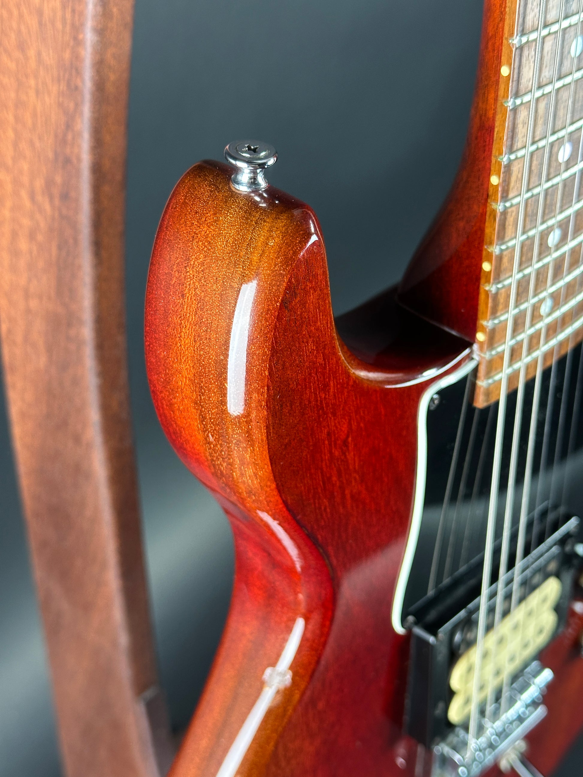 Close-up of a guitar's neck and body on a dark background