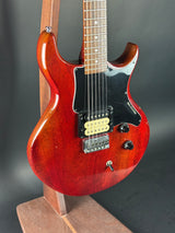 Red electric guitar on a dark background