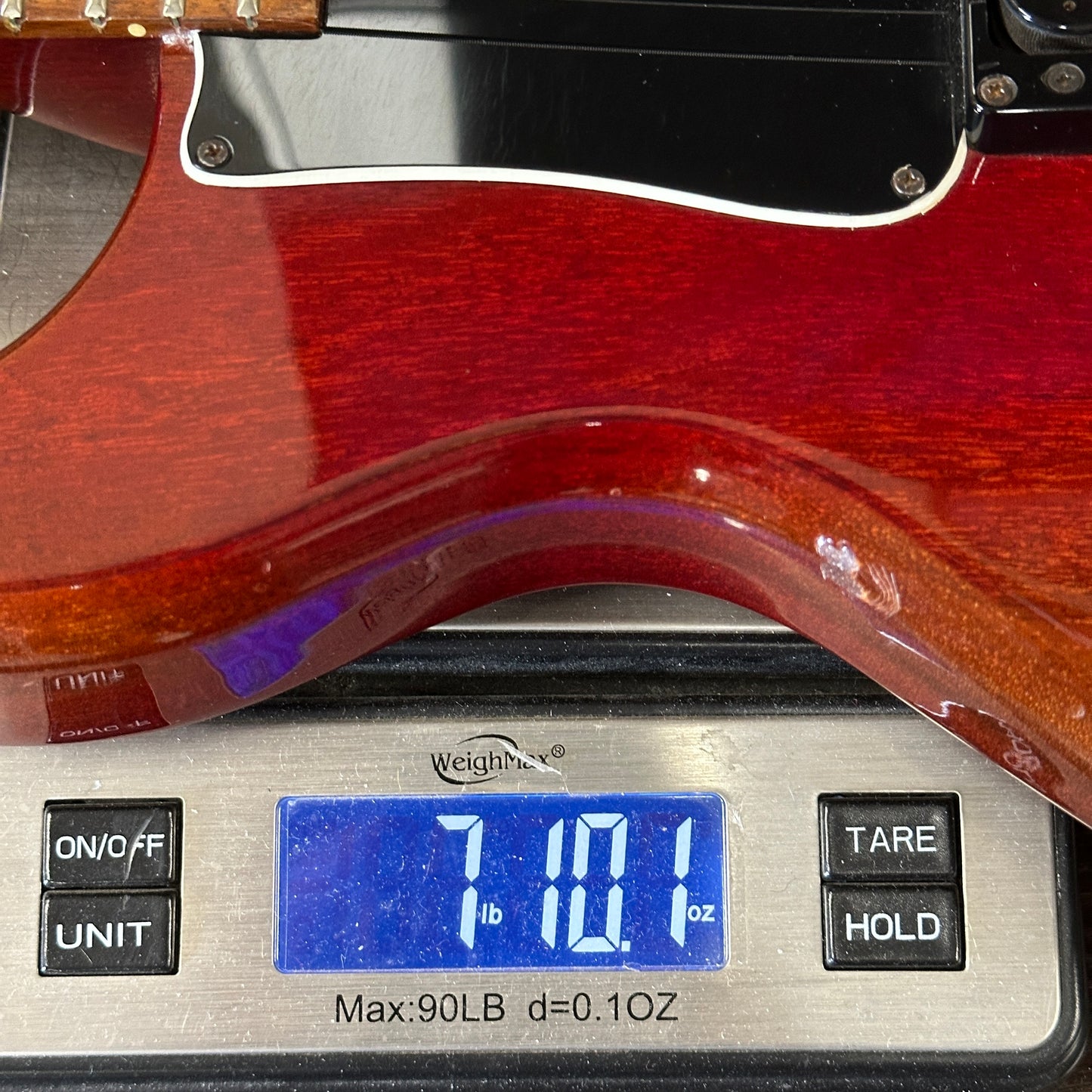 Guitar on a digital scale displaying weight