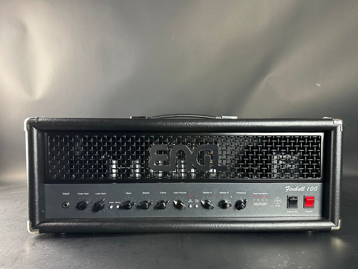 Fender guitar amplifier head on a reflective surface with a gray background