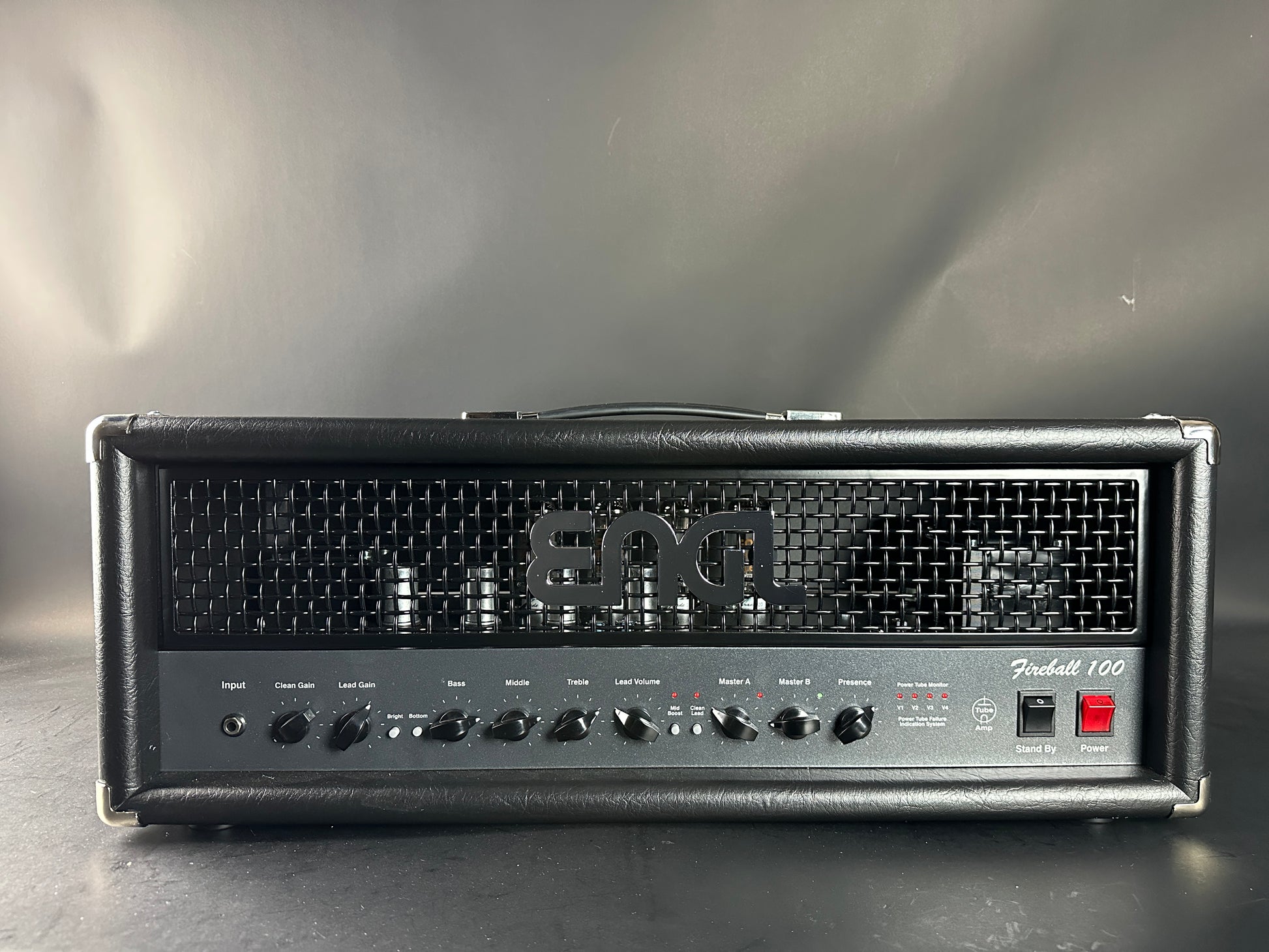 Fender guitar amplifier head on a reflective surface with a gray background
