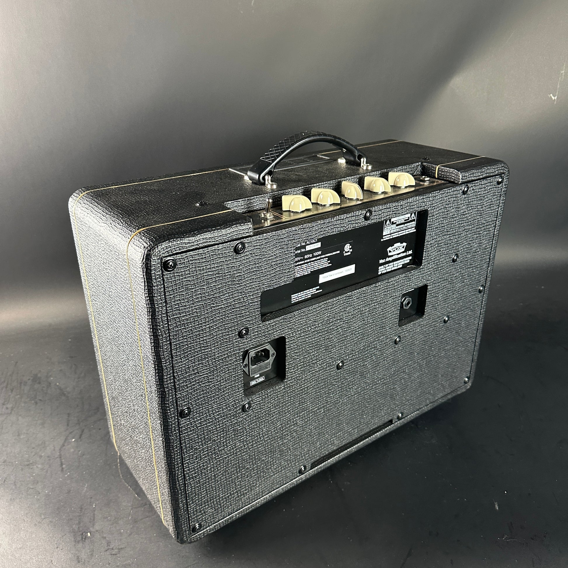 Guitar amplifier with control knobs on a gray background